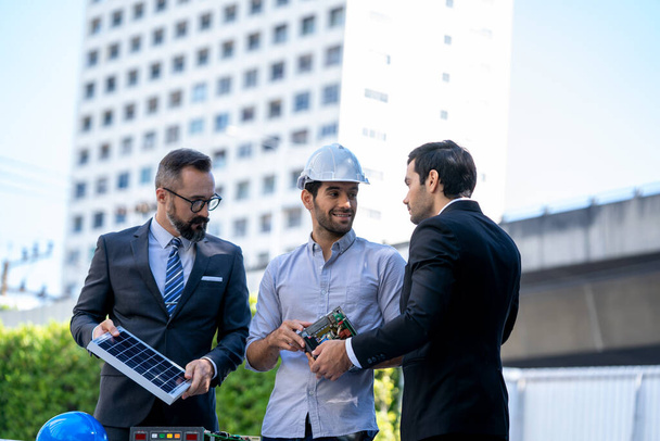 Empresarios e ingenieros discuten sobre energía renovable trabajando en un innovador concepto de batería de panel solar más eficiente. - Foto, imagen