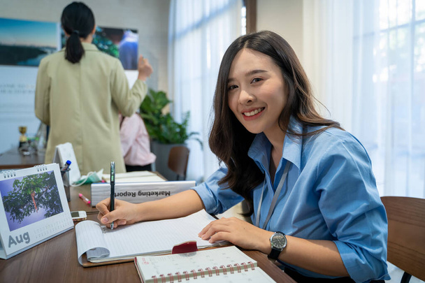 Happy smiling Asian business woman working at office. - Photo, image