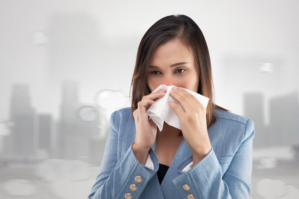 Businesswoman naso sensazione di bruciore a causa del fumo tossico e particolato nell'aria. Donna allergica, con un fazzoletto sul naso. PM2.5 - Foto, immagini