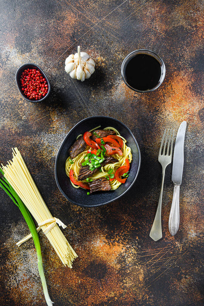 Kiinalainen nuudelit vihanneksia ja naudanlihaa musta kulho ylhäältä. - Valokuva, kuva