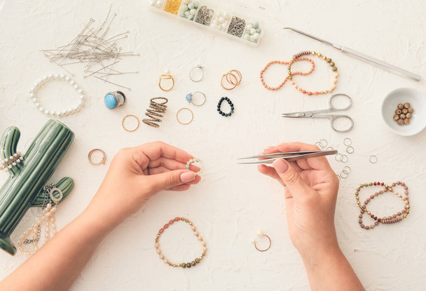Diseñadora femenina haciendo joyas sobre fondo claro - Foto, Imagen