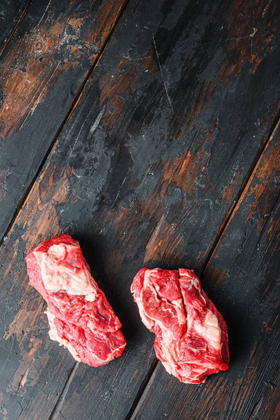 Organikus nyers marhahúsos márvány steak. Chuck szemforgatás a régi sötét fa asztal. felső nézet hely a szövegnek - Fotó, kép