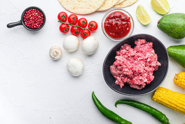 Mexikanische Tacos mit Gemüse und Fleisch. Zutat zum Kochen, Mais, Fleisch Draufsicht über weißen Hintergrund mit Platz für Text - Foto, Bild