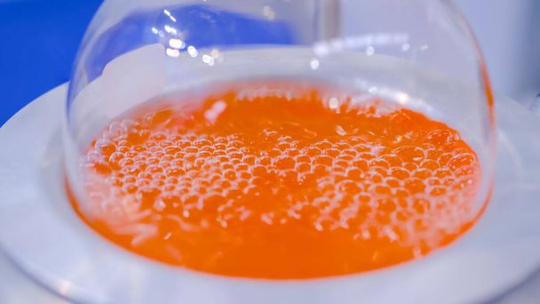 Laboratoryjny sprzęt grzewczy kolby okrągłej dolnej - wrzący pomarańczowy płyn: zbliżenie - Zdjęcie, obraz