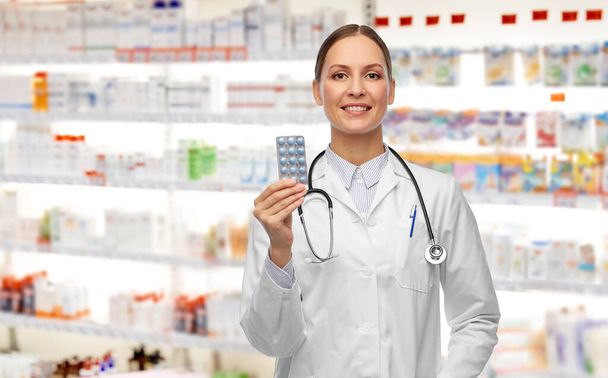 smiling female doctor holding medicine pills - Foto, Imagem