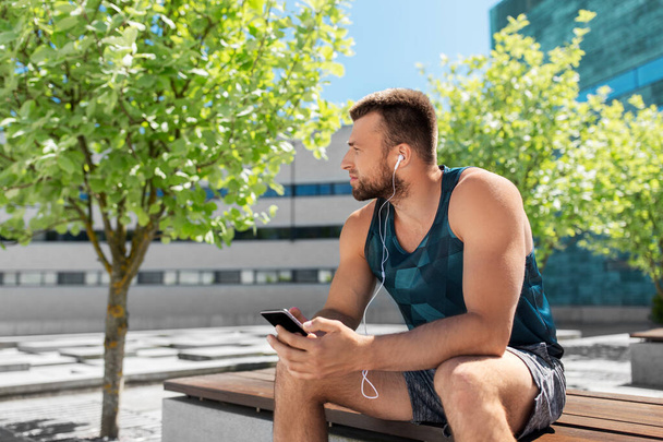 young athlete man with earphones and smartphone - Fotó, kép