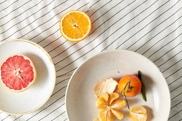 still life with mandarins and grapefruit on plate - Фото, изображение