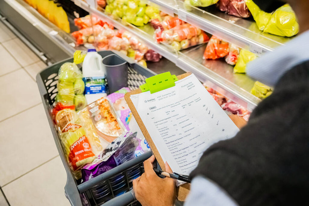 Cape Town, South Africa - December 10, 2020: Staff member picking grocery products from shelf for express home delivery service at local Pick n Pay supermarket  - Фото, зображення