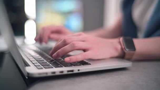 Close-up van vrouwen handen met slimme horloges met behulp van een laptop typen op een toetsenbord surfen op het internet online. Mooie bokeh lichten op een achtergrond. - Video