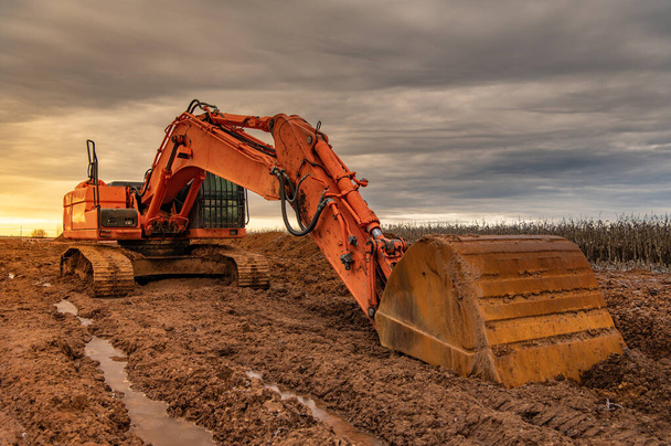 ぬれた泥だらけの冬の日に仕事をする掘削機 - 写真・画像