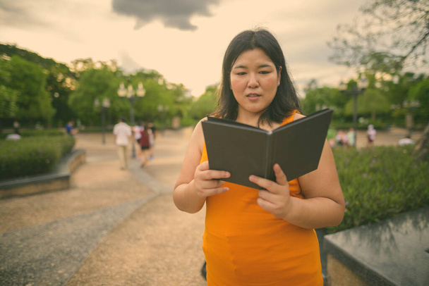 Hermosa mujer asiática con sobrepeso relajándose en el parque en la ciudad de Bangkok, Tailandia - Foto, Imagen