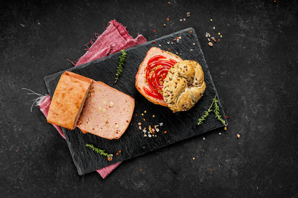 Flache Lagekomposition aus leckeren Hot Dogs und Sandwiches mit verschiedenen Belägen auf dunklem Hintergrund - Foto, Bild