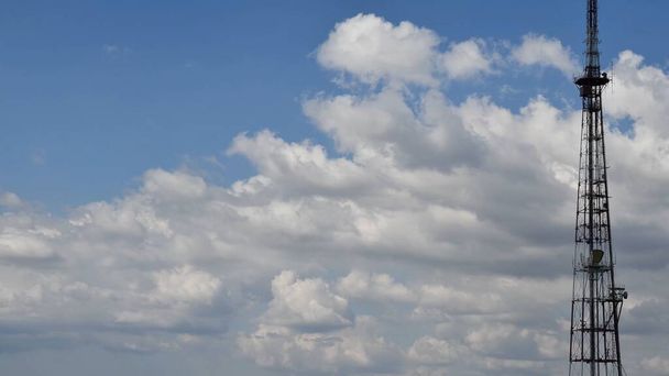 Wysokie niebieskie niebo i pływające białe chmury z wieżą komunikacyjną - Zdjęcie, obraz