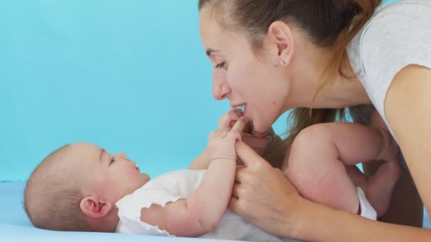 Nahaufnahme Mutter sanft küsst Baby genießen liebevolle Mutter spielerisch Pflege Kleinkind zu Hause teilen Verbindung mit ihrem Neugeborenen, gesunde Kinderbetreuung. - Filmmaterial, Video