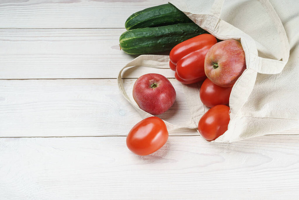 Light linen eco bag with fresh vegetables and fruits - 写真・画像