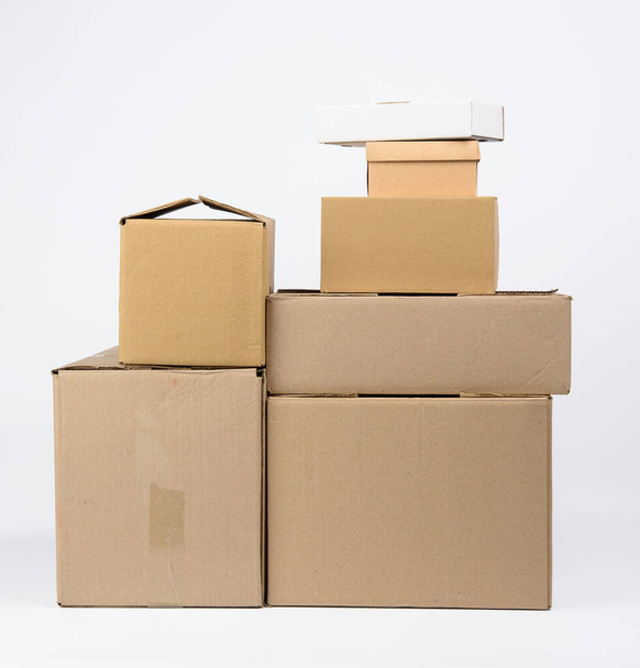 big stack of closed cardboard brown paper boxes on white background, moving concept - Photo, Image