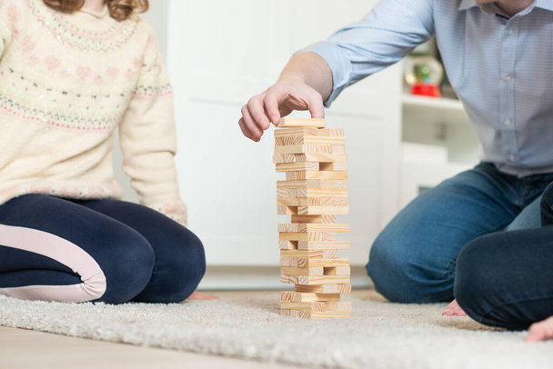 Happy young father playing with his cute daughter with wooden blocks at home - Fotoğraf, Görsel