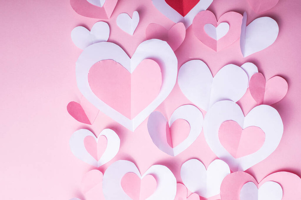 Valentine's Day festive background with pink and white paper hearts on a pink background for Valentines  holiday. Flatlay. Top view. Copyspace. - Photo, image