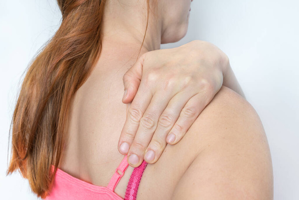 Nainen olkapää kipu pitää hänen kipeä olkapää - kehon kipu käsite - Valokuva, kuva