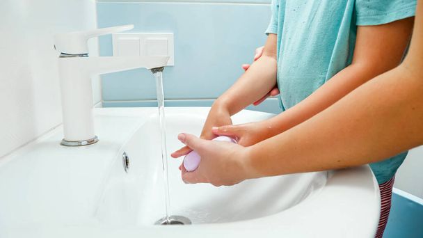 Fechar-se de vocêem outros lavar as mãos de seus filhos com sabão na pia do banheiro. Conceito de saúde e higiene - Foto, Imagem