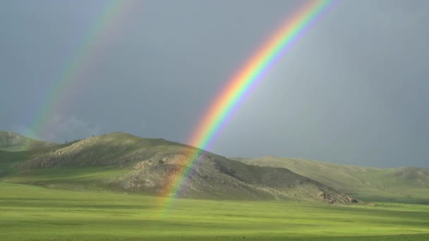 Dense Rainbow in treeless hill.Powerful hard dark curved colored colorful weather air meteorology background circle grassland prairie meadowpasture plateau tableland lowland plain sky spectrum sunlight majestic beauty wonderful excellent amazing best - Footage, Video
