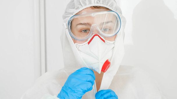 Portret van arts in beschermend pak, medisch masker nad veiligheidsbril - Foto, afbeelding