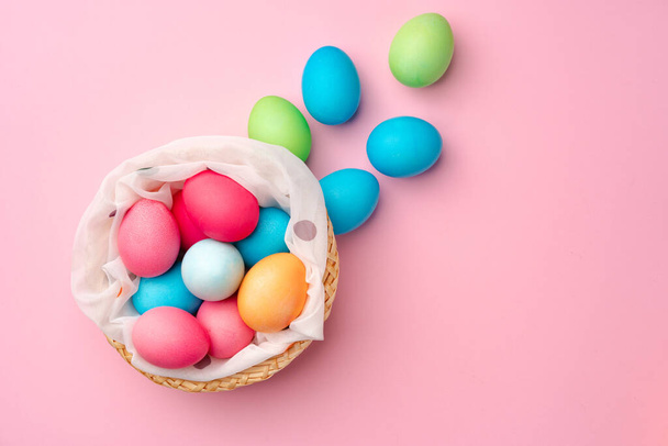 Painted Easter eggs in decorative nest on pink background - Valokuva, kuva