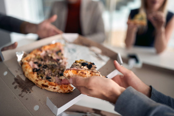 Pizza on today's menu in a break at company's canteen in a pleasant atmosphere. People, job, company, business concept. - Foto, imagen