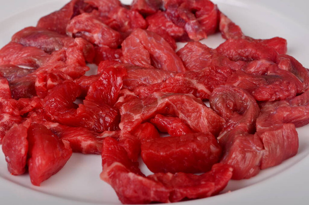 Raw beef meat cut into thin strips for beef Stroganoff on white plate - Photo, Image