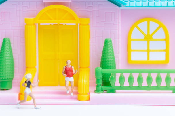 Мініатюрні люди , Пара біжить біля свого будинку разом , концепція здорового способу життя
 - Фото, зображення