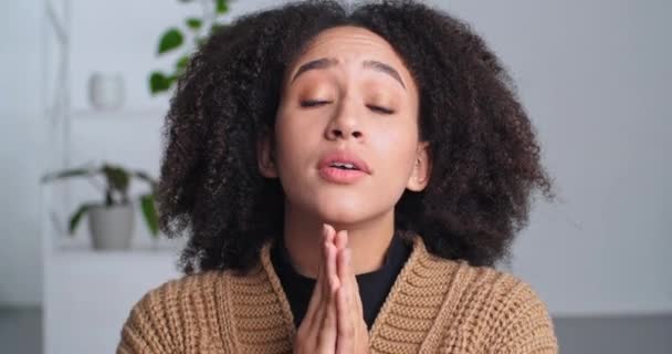 Schattig Afro-Amerikaanse zwarte vrouw vouwt haar handen op verzoek smeken maakt gebaar van verontschuldiging vraagt om vergiffenis grimaces gezicht drukt medelijden, emotionele dame vrouwelijk gezicht op zoek naar camera - Video