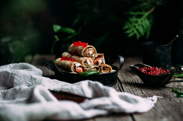  palačinky s červeným kaviárem ryby a smetanový sýr na dřevěném pozadí - Fotografie, Obrázek