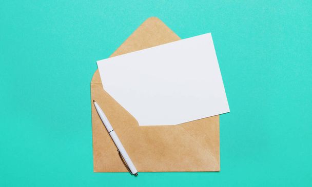 On a green background - an open craft envelope and an empty card for inserting text or illustrations. - Photo, Image