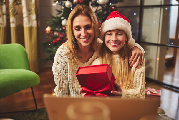 Happy woman with daughter opening presents on Boxing Day - 写真・画像