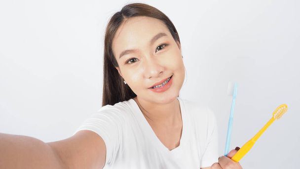 Braces teeth. Dental brace sexy girl smile holding toothbrush and looking to camera. white teeth with blue braces. Dental care. Asian woman with contact lens and orthodontic. Oral care concept. - Photo, Image