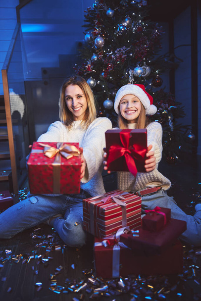 Happy woman with daughter receiving gifts for Christmas - Foto, Imagen
