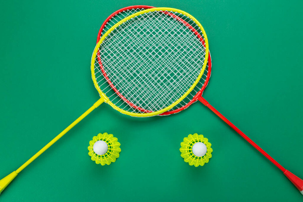 Shuttlecock and racket for playing badminton on a green background. Minimalism. Concept summer entertainment. Sport games - Valokuva, kuva