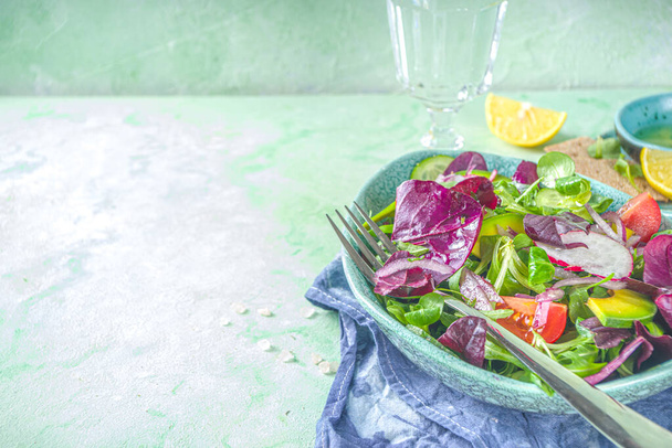 Salada de primavera colorida fresca - abacate, legumes frescos, folhas de salada e queijo feta, espaço de cópia de fundo de concreto verde claro - Foto, Imagem