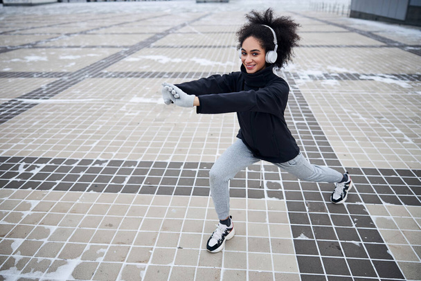 Pleased athletic woman training her leg muscles - Fotoğraf, Görsel