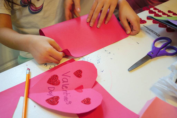 Childs kädet tehdessään kotitekoinen Ystävänpäivä kortit taidetta ja käsitöitä - Valokuva, kuva