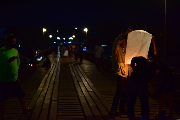 Άνθρωποι με ιπτάμενο φανάρι τη νύχτα της πόλης - Φωτογραφία, εικόνα