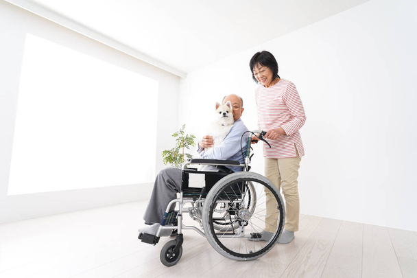 idosa cuidando de seu marido na cadeira de rodas - Foto, Imagem