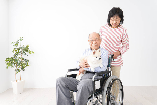 車椅子で夫の世話をしている老婦人は - 写真・画像