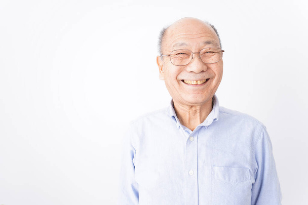Hombre mayor sonríe sobre fondo blanco - Foto, Imagen