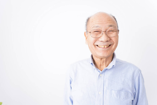 Älterer Mann lächelt auf weißem Hintergrund - Foto, Bild