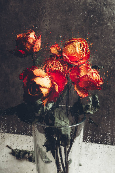 Bando de belas flores desbotadas através do vidro com gotas de chuva - Foto, Imagem