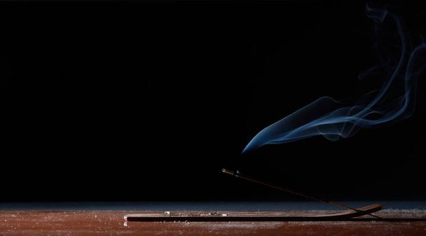 Encens bâton sur une table avec fond noir brûle paisiblement dans le silence - Photo, image