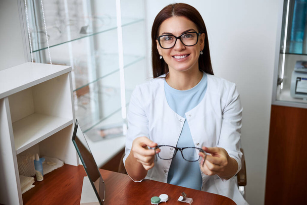Eye care professional suggesting a pair of glasses - Fotó, kép