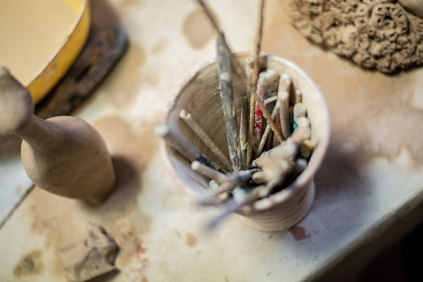 Ceramista femminile che lavora su argilla sulla ruota di un vasaio, mani vicine. Fare una pentola di argilla fatta a mano in laboratorio. Lezione di ceramica, hobby. - Foto, immagini