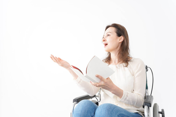 Young woman in a wheelchair reading books - Foto, immagini